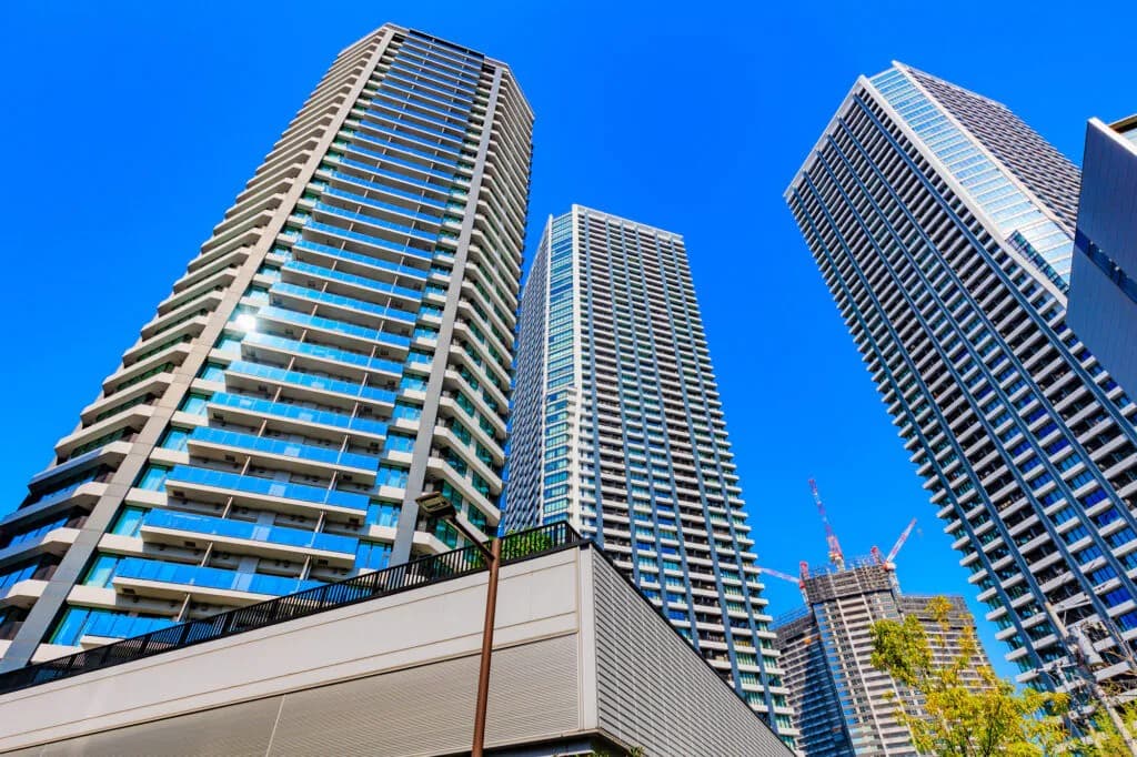 都市の高層ビル群と青空。成長と都市開発を象徴するローアングル写真